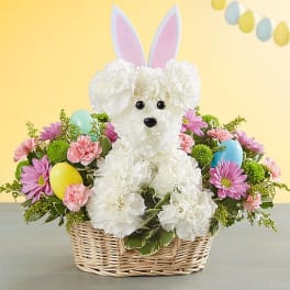 Basket arrangement with a white teddy bear and pastel flowers
