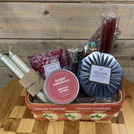 Holiday gift basket with candles and candle holders in a woven tray