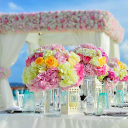 Pink and white floral centerpieces on a decorated outdoor table