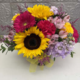 Mixed bouquet with sunflowers, pink gerberas, and pastel blooms