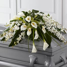 White floral casket spray with calla lilies and orchids