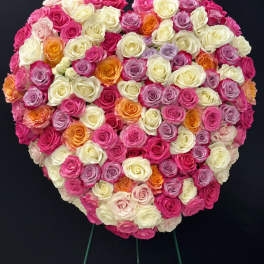 Heart-shaped arrangement of multicolored roses on a stand
