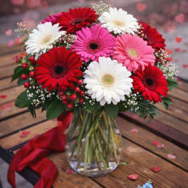 Bouquet of red, pink, and white gerbera daisies in a glass vase