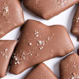 Close-up of milk chocolate pieces topped with coarse sea salt