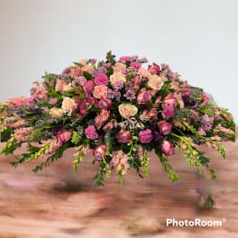 Low floral centerpiece with pink and lavender roses and mixed blooms