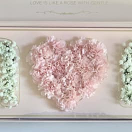 Pink heart-shaped floral box with white flower letters on each side