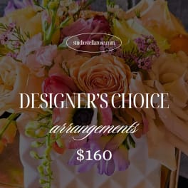 Colorful mixed flower arrangement with roses and ranunculus in a white textured vase