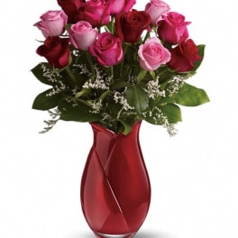 Bouquet of pink and red roses in a red glass vase