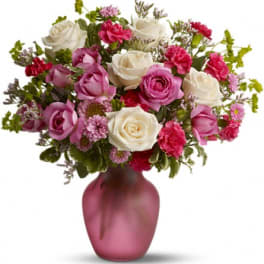 Pink and white rose bouquet in a frosted pink vase