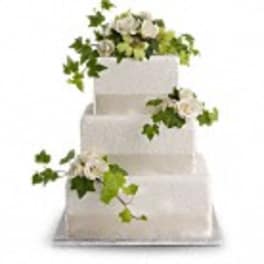 Three-tier white cake with white flowers and green ivy