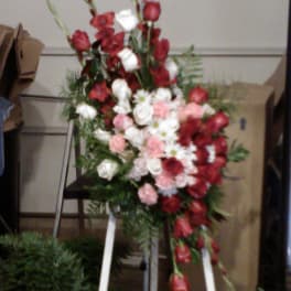Standing floral spray with red, white, and pink flowers on an easel