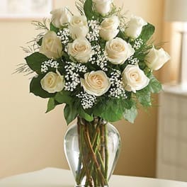 White roses arranged in a clear glass vase