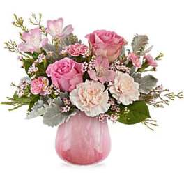 Pink roses and carnations arranged in a pink glass vase
