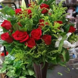 Red roses and white lilies arranged in a tall vase