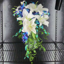 White lilies with blue-purple orchids in a glass vase