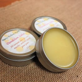 Three tins of yellow salve on burlap fabric
