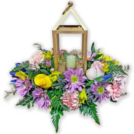 Floral lantern centerpiece with mixed pink, purple, and yellow blooms