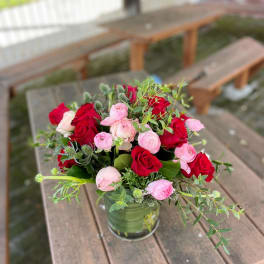 Red and pink rose bouquet in a glass vase