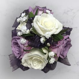 Bouquet of white and lavender roses with dark ribbon accents