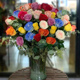 Large bouquet of multicolored roses in a clear glass vase
