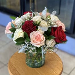 Bouquet of red, pink, and white roses in a glass vase