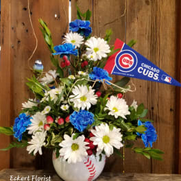 Baseball-themed flower arrangement in a baseball vase with a Cubs pennant