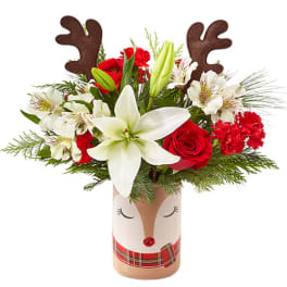 Holiday bouquet with red and white flowers in a reindeer vase