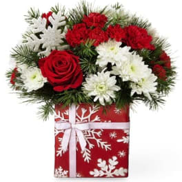 Red and white flowers in a gift box with a white ribbon