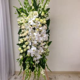 Tall standing floral spray with white orchids and cream roses