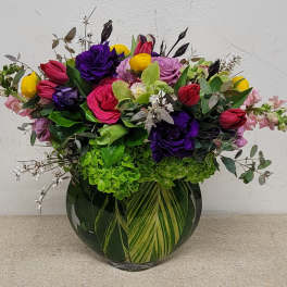Mixed bouquet of colorful roses and tulips in a glass vase