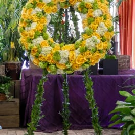 Large yellow and white floral wreath on a stand