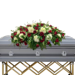 Red and white floral spray on a silver casket