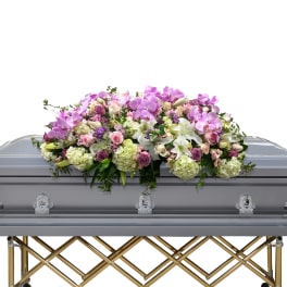 Floral casket spray with pink orchids, lilies, and roses
