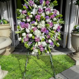 Large standing floral spray with white, lavender, and green blooms