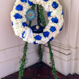 Large floral wreath with blue, white, and blush flowers on a stand