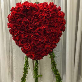 Heart-shaped red rose arrangement with hanging greenery