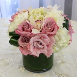 Pink roses and white flowers arranged in a green vase