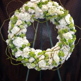White and green floral wreath on a stand