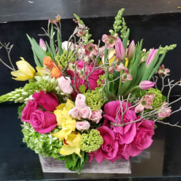 Mixed bouquet in a rectangular wooden box with pink, yellow, and green flowers