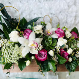 Pink and white roses with white orchids in a wooden box