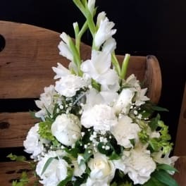 White floral arrangement with tall gladiolus and mixed blooms in a basket