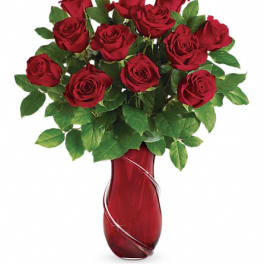 Red roses arranged in a red glass vase
