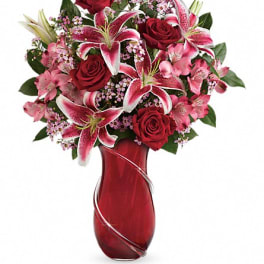 Red roses and pink lilies arranged in a red vase