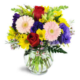 Mixed bouquet of roses, daisies, and purple flowers in a glass vase