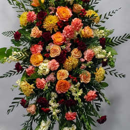 Large standing floral spray with roses, carnations, and white spikes