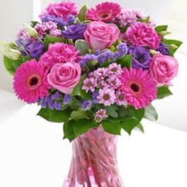 Pink and purple mixed bouquet in a pink glass vase