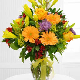 Bouquet of orange and yellow flowers in a clear glass vase
