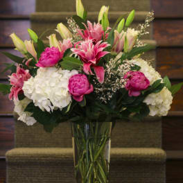 Pink lilies and white hydrangeas in a clear glass vase