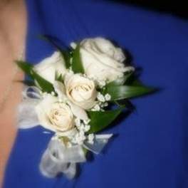 White rose corsage with ribbon on a blue dress