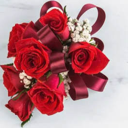 Bouquet of red roses with burgundy ribbon and white filler flowers